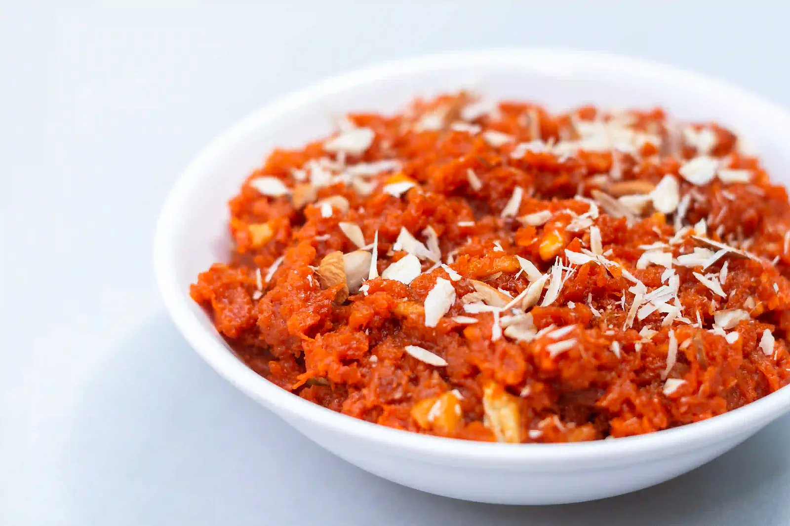 A bowl of Indian sweet garnished with nuts