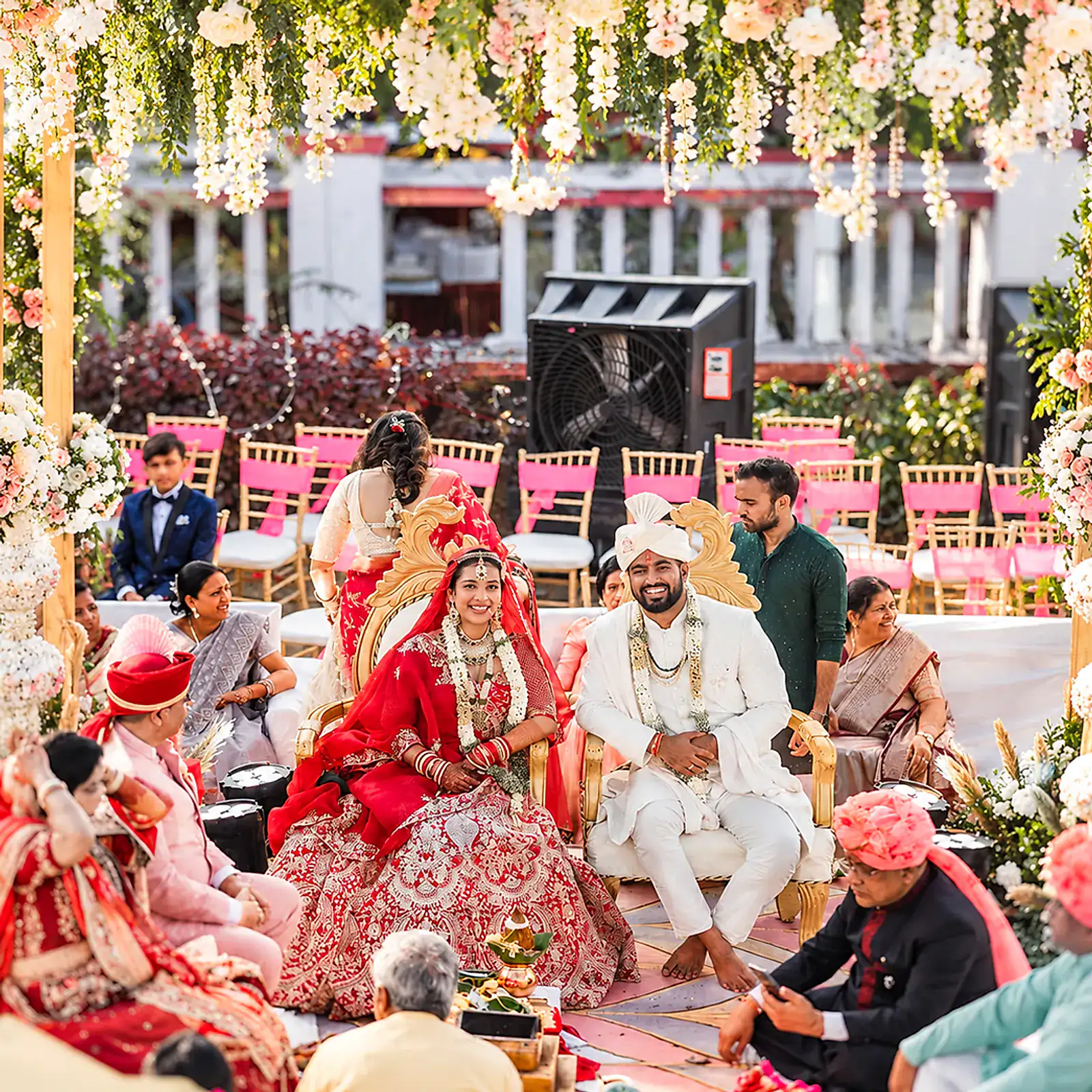 Bride and groom seated for their wedding ceremony, family gathered on the lawn