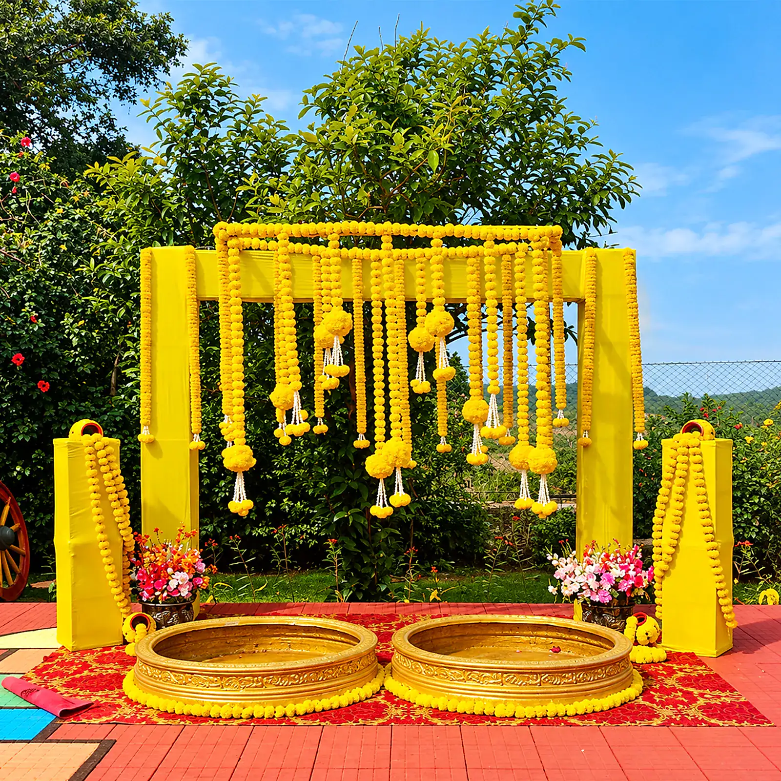 A yellow marigold haldi setup with brass urlis on the lawn