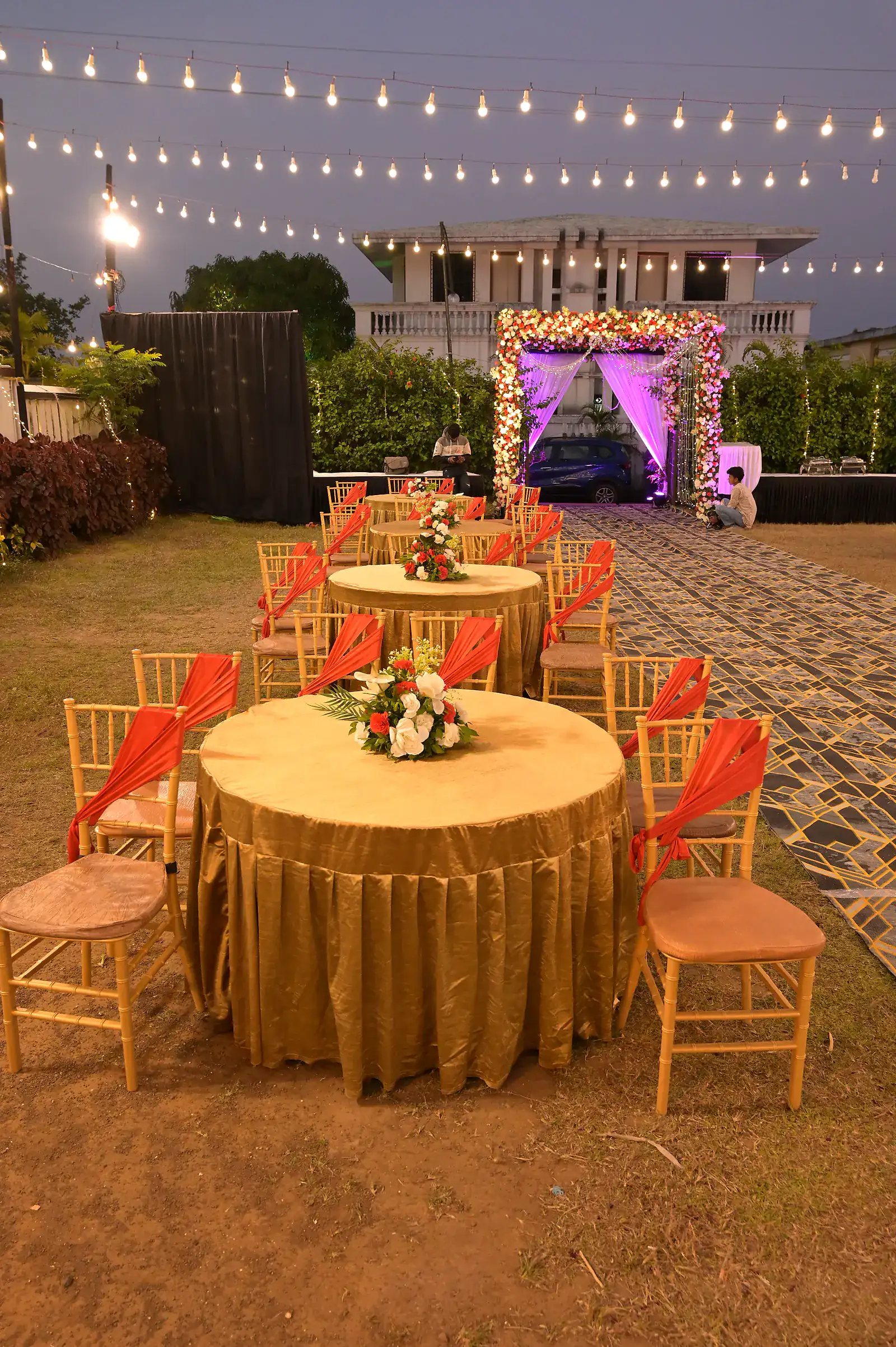 Round dining tables with floral centrepieces on the lawn